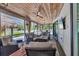 Relaxing screened porch with comfortable furniture, a ceiling fan, and a TV at 307 Bucknell Rd, Venice, FL 34293