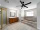 Spacious bathroom with tiled floors, a walk-in shower, a vanity, and a built-in tiled tub at 318 Oakwood Cir, Englewood, FL 34223