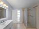 Modern bathroom featuring a sleek vanity, tiled shower with glass door, and ample natural light at 318 Oakwood Cir, Englewood, FL 34223