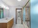 Bathroom with a vanity, mirror, and shower with glass door and tile surround at 318 Oakwood Cir, Englewood, FL 34223