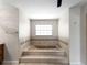 Bathroom featuring a built-in tiled bathtub with a window providing natural light at 318 Oakwood Cir, Englewood, FL 34223