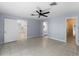 Light-filled bedroom with tile floors, ceiling fan, and doors leading to an ensuite bath and closet at 318 Oakwood Cir, Englewood, FL 34223