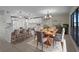Bright, open dining and kitchen area featuring modern white cabinetry, pendant lighting, and a large wooden dining table at 318 Oakwood Cir, Englewood, FL 34223