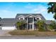 Stately two-story home with a gray roof, manicured landscaping and a brick driveway, offering timeless curb appeal at 318 Oakwood Cir, Englewood, FL 34223