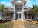 Front view of property with elegant entry, double doors, symmetrical windows, and manicured landscaping at 318 Oakwood Cir, Englewood, FL 34223