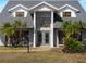Exterior of home showcases an elegant front entrance, double doors, mature trees, and landscaped yard at 318 Oakwood Cir, Englewood, FL 34223