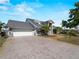 Well-kept home with attached garage and a wide, paved driveway, complemented by lush palm trees at 318 Oakwood Cir, Englewood, FL 34223