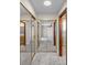 Hallway view with closet that have mirrored sliding doors and neutral carpeting at 318 Oakwood Cir, Englewood, FL 34223