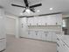 Bright kitchen featuring white cabinets, modern hardware, and a ceiling fan at 318 Oakwood Cir, Englewood, FL 34223