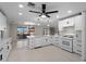 Bright and open kitchen with white cabinets, quartz countertops, stainless appliances, and seamless flow to dining area at 318 Oakwood Cir, Englewood, FL 34223
