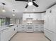 Modern kitchen featuring white cabinets, stainless steel appliances, and a spacious island for food preparation and dining at 318 Oakwood Cir, Englewood, FL 34223