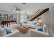 Inviting living room with ample seating, piano, and staircase; perfect for entertaining and comfortable living at 318 Oakwood Cir, Englewood, FL 34223
