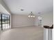 Bright living room features a bay window, and modern lighting fixture, plus views to an adjoining kitchen at 318 Oakwood Cir, Englewood, FL 34223