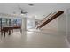 Bright living area showcasing a piano, large windows, and a staircase at 318 Oakwood Cir, Englewood, FL 34223