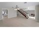 Spacious living room with light wood floors, staircase to the second floor, and views to the kitchen at 318 Oakwood Cir, Englewood, FL 34223
