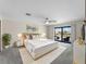 Elegant main bedroom with a plush bed, decorative pillows, and sliding glass doors to a private balcony at 318 Oakwood Cir, Englewood, FL 34223