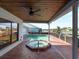 Covered patio featuring a pool and hot tub, perfect for outdoor relaxation and entertaining with canal views at 318 Oakwood Cir, Englewood, FL 34223
