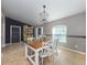 Dining area with a rustic table and chairs, a stylish pendant light, and neutral wall colors at 3255 Tally Ho Rd # 1, North Port, FL 34291