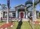 Welcoming gray home exterior featuring a red front door and tropical landscaping, offering curb appeal at 3255 Tally Ho Rd # 1, North Port, FL 34291