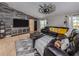 Comfortable living room with a large sectional sofa, statement ceiling fan, and a modern TV console at 3255 Tally Ho Rd # 1, North Port, FL 34291