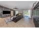Cozy living room featuring a comfortable sectional sofa, wood accent wall, and sliding glass doors to the patio at 3255 Tally Ho Rd # 1, North Port, FL 34291