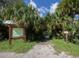 Entrance to the river launch area with signage, gravel path, and palm trees at 3255 Tally Ho Rd # 1, North Port, FL 34291