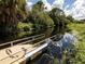 Dock for water access, surrounded by lush vegetation and calm water reflecting the sky at 3255 Tally Ho Rd # 1, North Port, FL 34291