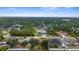 An aerial view displays houses interspersed with trees, creating a peaceful neighborhood scene at 3870 Log Cabin Rd, North Port, FL 34291