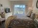 Calm bedroom featuring a queen bed and tranquil views of the lake at 406 Laurel Lake Dr # 103, Venice, FL 34292