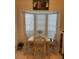 Cozy breakfast nook with natural light, a glass-top table, and comfortable rattan chairs at 406 Laurel Lake Dr # 103, Venice, FL 34292
