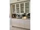 Custom built-in cabinet with glass shelves and a mirror backsplash in the dining area at 406 Laurel Lake Dr # 103, Venice, FL 34292