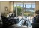 Cozy sunroom living area with comfortable seating, a desk, and a scenic view of the water at 406 Laurel Lake Dr # 103, Venice, FL 34292