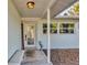 Inviting front porch with decorative glass door, bench seating, and stone accents providing curb appeal at 421 Blackburn Rd, Nokomis, FL 34275