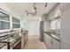 Modern kitchen with sleek gray cabinets, stainless steel appliances, and stylish track lighting at 421 Blackburn Rd, Nokomis, FL 34275