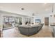 Open-concept living room featuring neutral tile floors, modern ceiling fan, and sliding glass doors to lanai at 421 Blackburn Rd, Nokomis, FL 34275