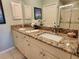 Bathroom with granite countertop, double sinks, neutral tile flooring, and decorative accents at 4213 Vicenza Dr # A2, Venice, FL 34293
