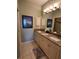 Bright bathroom featuring double granite vanity, neutral walls, and decorative art at 4213 Vicenza Dr # A2, Venice, FL 34293