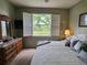 Bedroom featuring a window with shutters, a dresser with mirror, and soft lighting at 4213 Vicenza Dr # A2, Venice, FL 34293