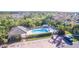 Aerial view of the fenced community pool area with cabana and lounge chairs and a blue truck parked nearby at 4213 Vicenza Dr # A2, Venice, FL 34293