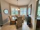 Charming dining area with a glass table, upholstered chairs, and natural light at 4213 Vicenza Dr # A2, Venice, FL 34293