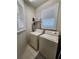 A well lit laundry room features a washer, dryer, storage shelf, and tiled floors at 4213 Vicenza Dr # A2, Venice, FL 34293