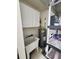 Utility room with sink, hot water heater, white cabinet, and shelving for optimal storage at 4213 Vicenza Dr # A2, Venice, FL 34293