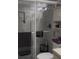 Bright bathroom featuring tiled walls, glass-enclosed shower, and a toilet with storage at 469 Albee Farm Rd # V19, Venice, FL 34285