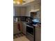 Updated kitchen featuring gray cabinets, stainless steel appliances, and granite countertops at 469 Albee Farm Rd # V19, Venice, FL 34285