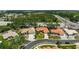 An aerial view shows a well-maintained home with a red tile roof, surrounded by lush landscaping and mature trees at 4856 Jacaranda Heights Dr, Venice, FL 34293