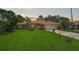 Charming home featuring lush landscaping, a terracotta roof, arched entryway, and a well-manicured lawn at 4856 Jacaranda Heights Dr, Venice, FL 34293