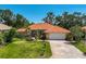 Beautiful single-story home features a tile roof, arched entryway, and a brick-paved driveway surrounded by lush landscaping at 4856 Jacaranda Heights Dr, Venice, FL 34293