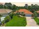 Charming single-story home boasting lush landscaping, brick driveway, and a vibrant orange tile roof at 4856 Jacaranda Heights Dr, Venice, FL 34293