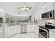Modern kitchen featuring stainless steel appliances, white cabinets, and granite countertops at 4856 Jacaranda Heights Dr, Venice, FL 34293
