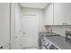 Bright laundry room with modern washer and dryer, white cabinets, and a storage closet at 4856 Jacaranda Heights Dr, Venice, FL 34293